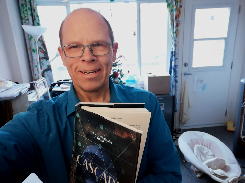 Photo of publisher Geoffrey Dow posing with hardcover copy of Rachel A. Rosen's novel Cascade.